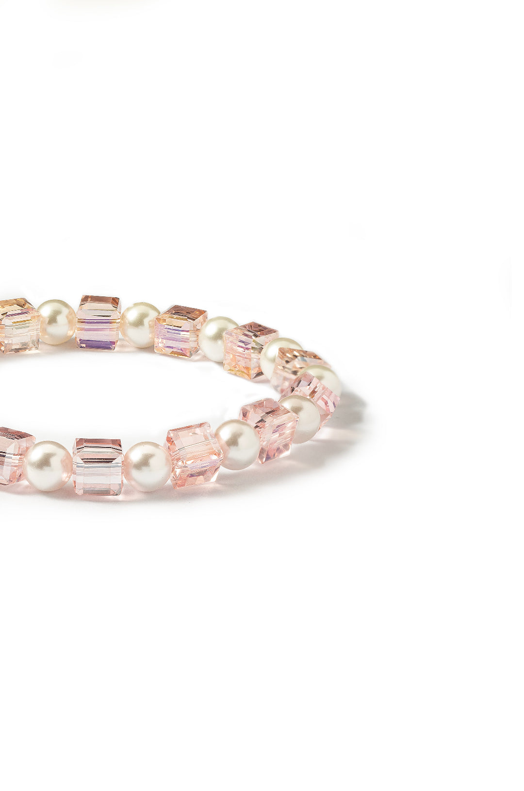 Angled view of the Aiko Tanaka Kosai no Wa bracelet with pink crystal cubes and white pearls on a white background