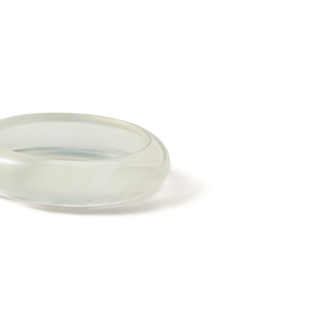 Aiko Tanaka ring component close-up, a smooth translucent white jade band resting on a white background