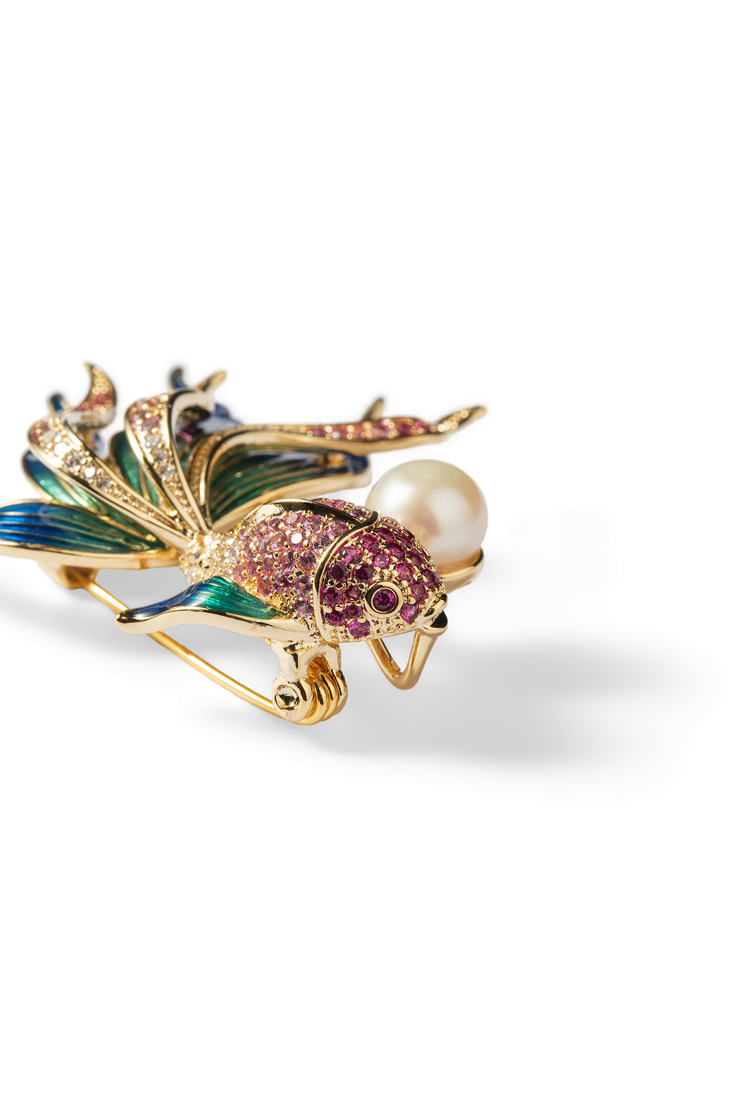 Side view of the Aiko Tanaka Nishiki no Yume koi fish brooch with blue enamel fins, pink crystals and a white pearl