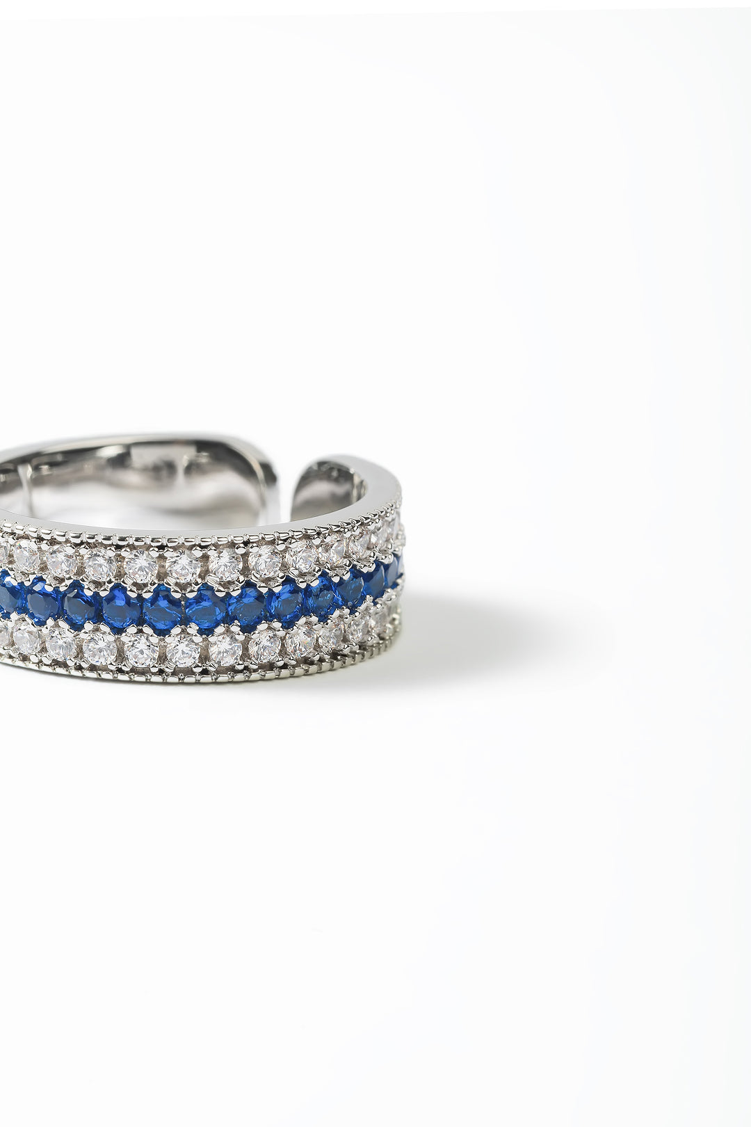 Aiko Tanaka Kiseki silver band ring with rows of blue stones and white crystals, angled view on white