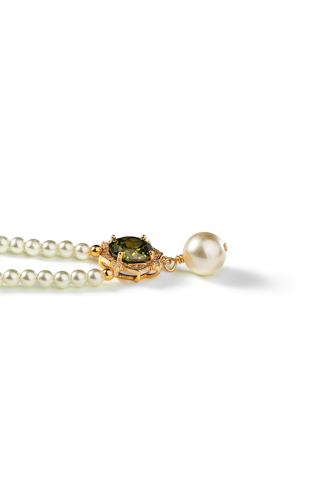 Aiko Tanaka Hasuike necklace laid flat, a pearl strand with a gold-set green stone and a white pearl, white background