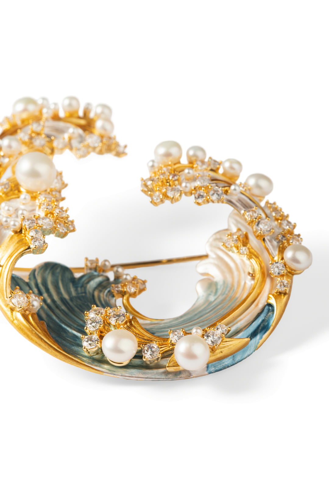 Aiko Tanaka Shiosai no Wa brooch, a gold wave curl with blue enamel, crystals and white pearls, on white