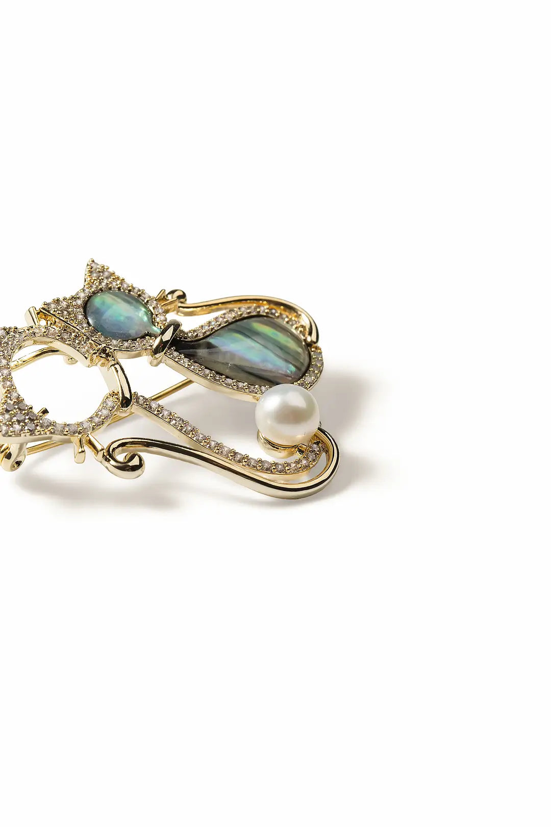 Aiko Tanaka Kimagure brooch side view, a gold outline cat with teal stones and a white pearl, on a white background