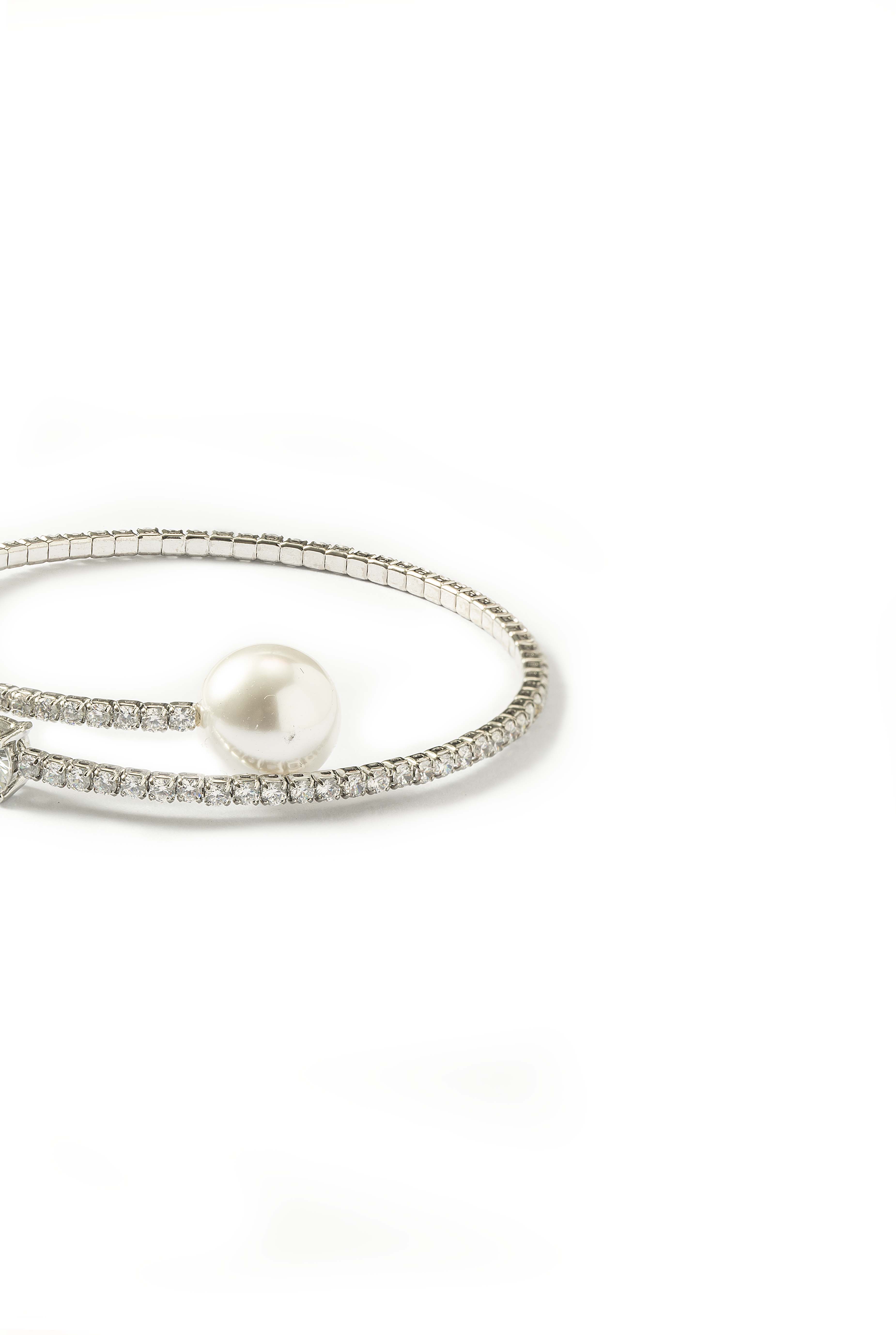 Side view of the Aiko Tanaka Kinko no Wa crystal wrap bracelet with a white pearl end, on a white background