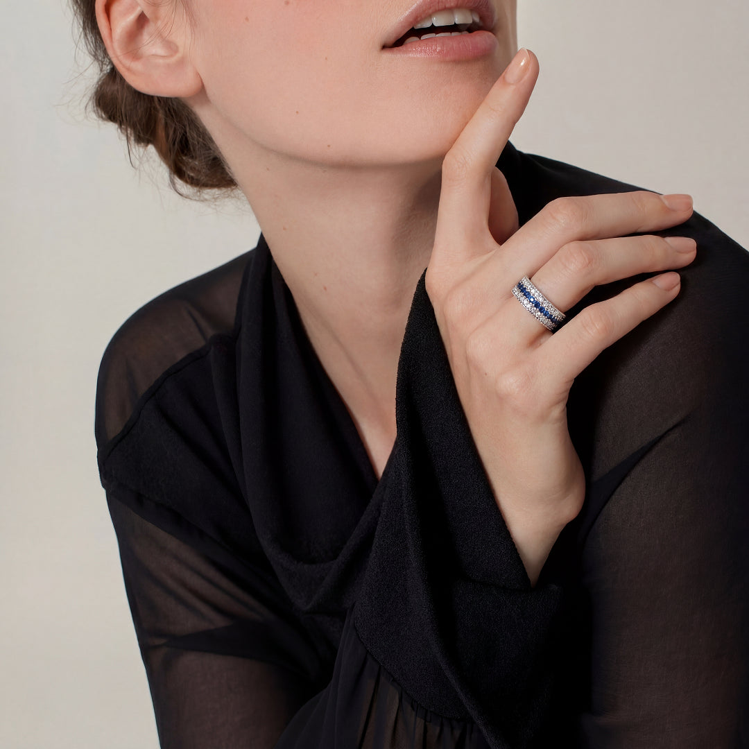Woman in a sheer black top touching her chin while wearing an Aiko Tanaka Kiseki stacked ring with blue stones