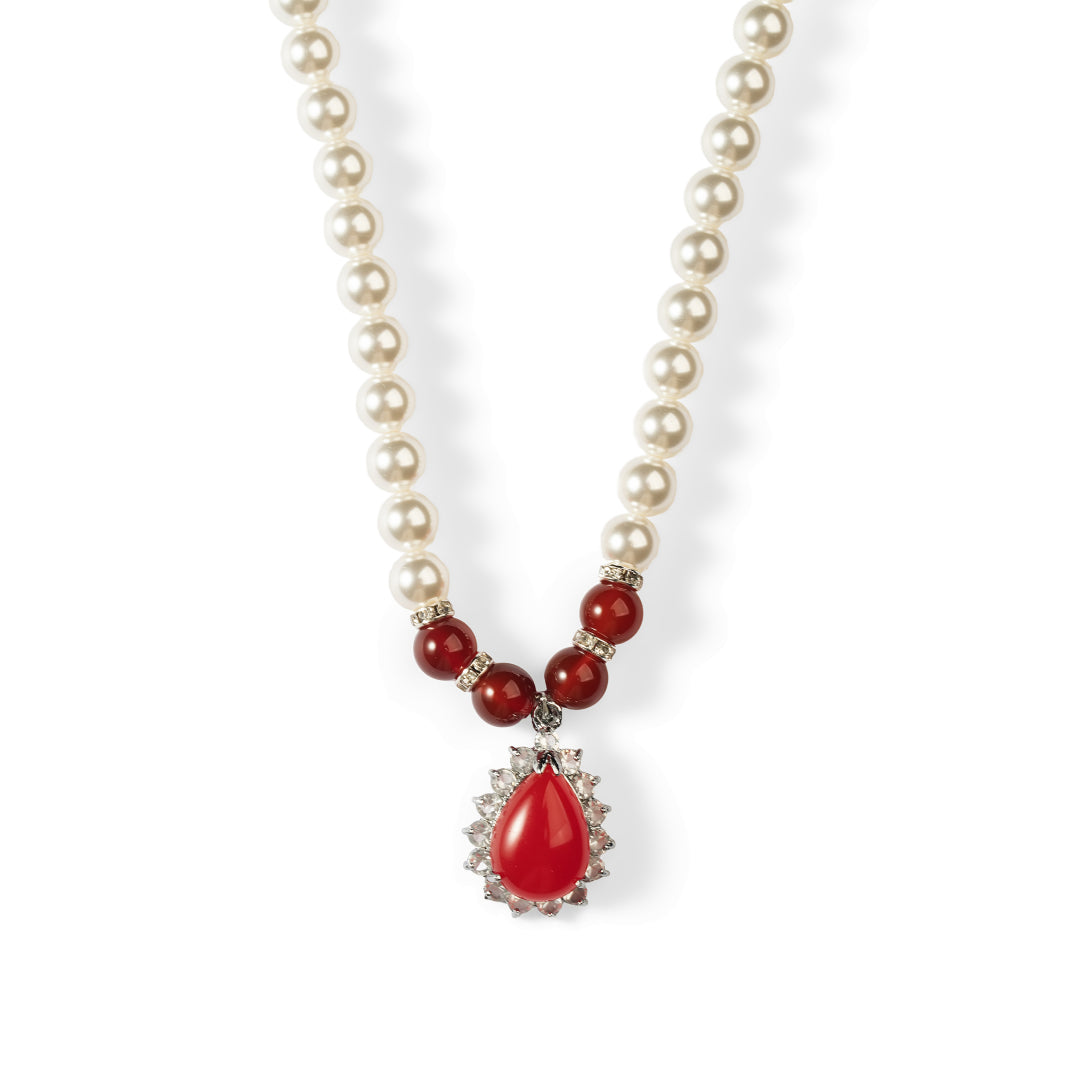 Aiko Tanaka Kokei necklace of white pearls and red beads with a red teardrop pendant framed by crystals, on white