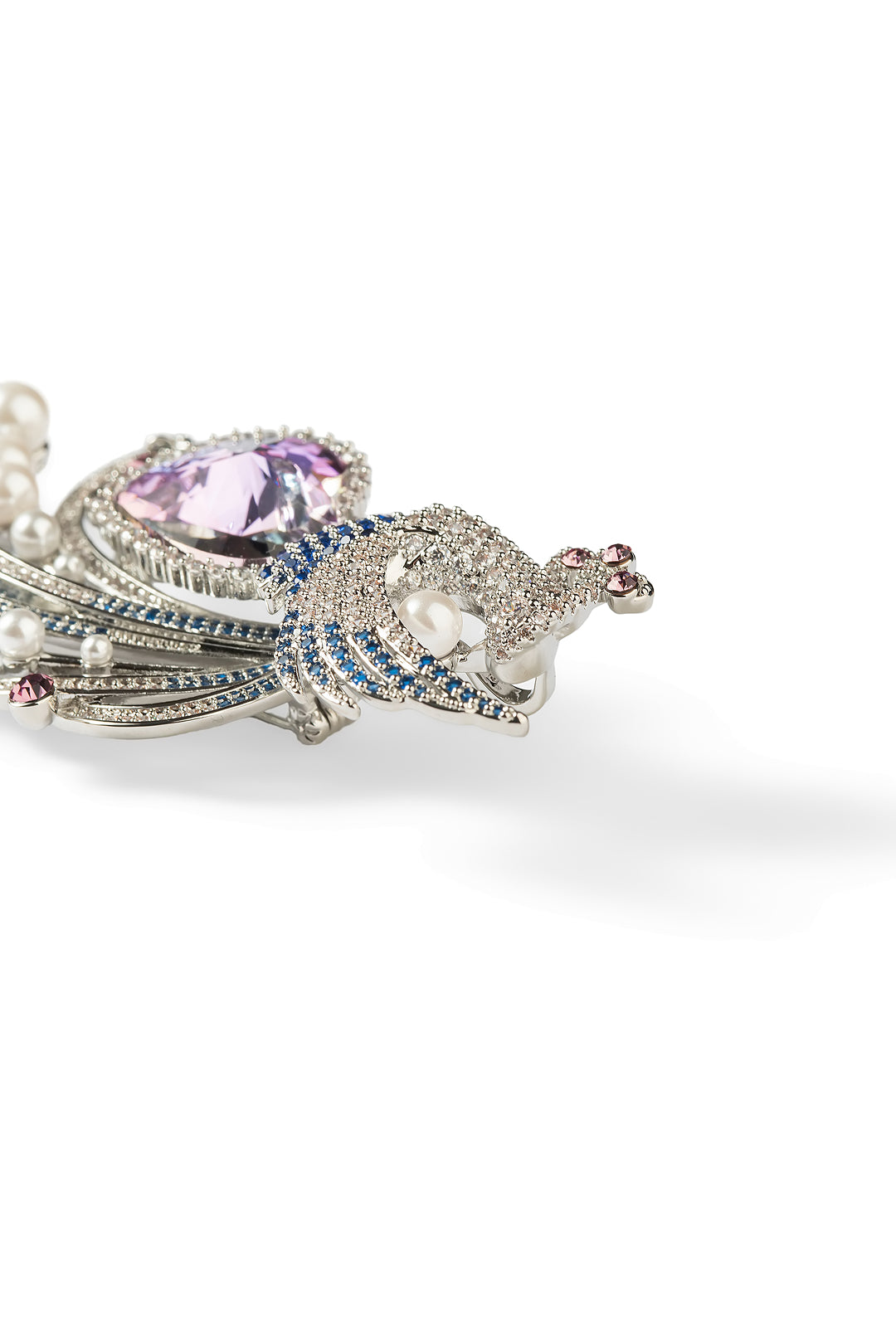 Side view of the Aiko Tanaka Kujaku no Shingetsu peacock brooch with a purple heart stone and pave crystal plumes