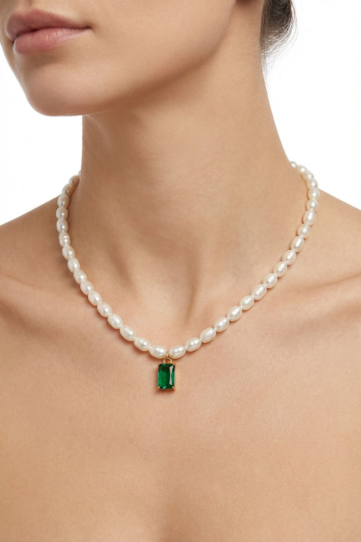 Model with bare shoulders wearing the Aiko Tanaka Midori no Hazama rice pearl necklace with a green rectangular pendant