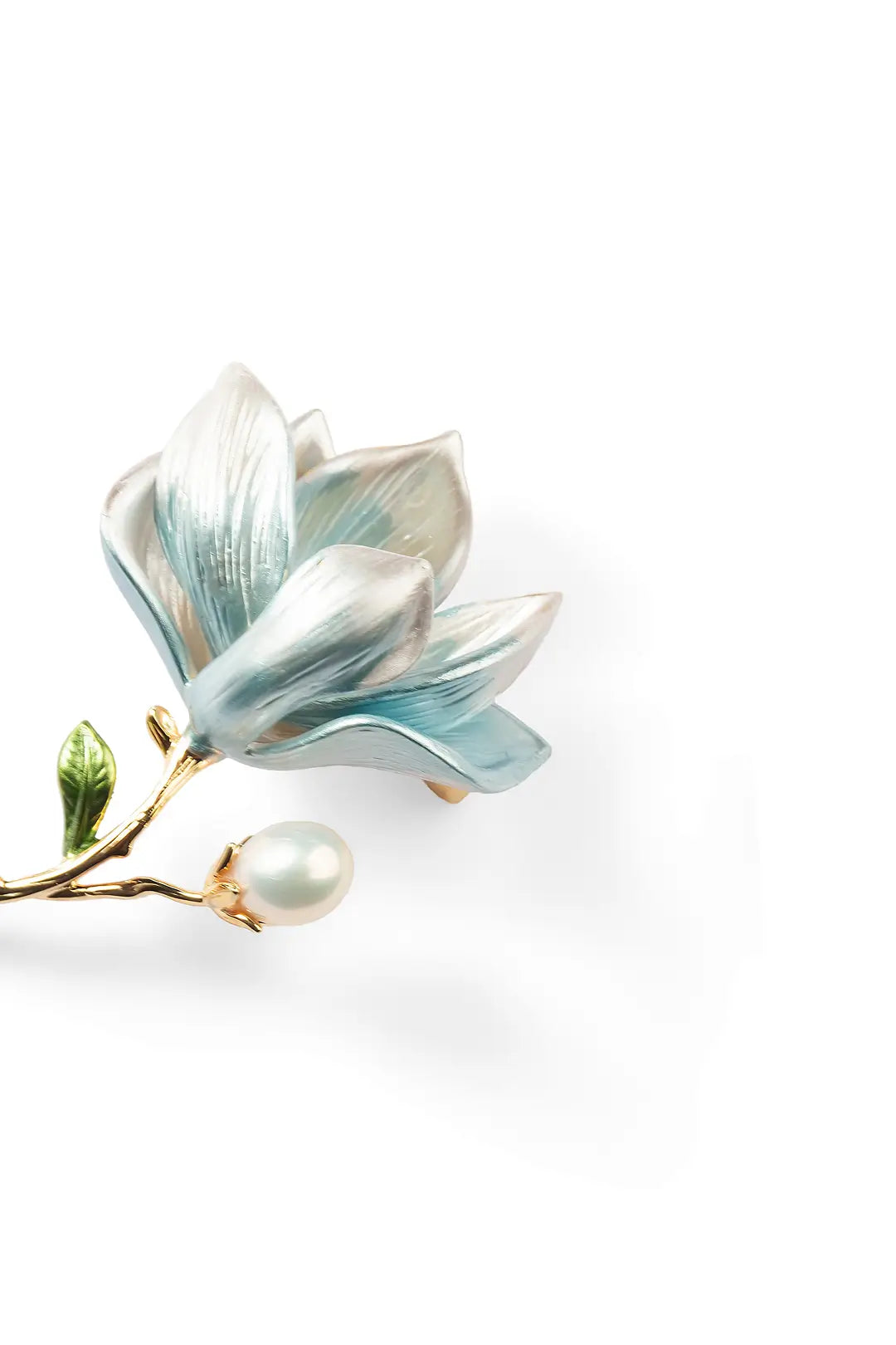 Aiko Tanaka Mizuhana brooch close-up, pale blue enamel magnolia petals with a gold stem and white pearl, white background