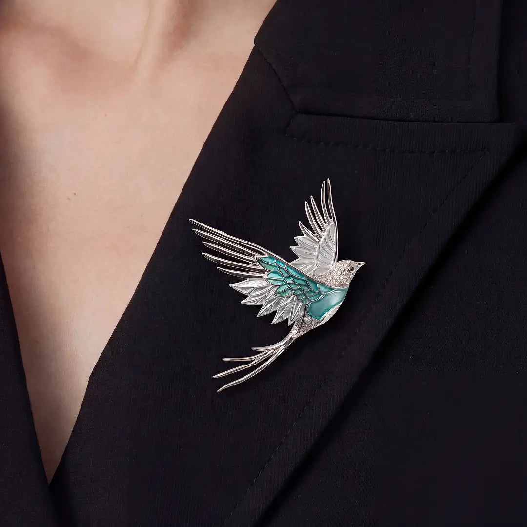 Woman in a black blazer wearing the Aiko Tanaka Mizuhane teal enamel swallow brooch on her lapel