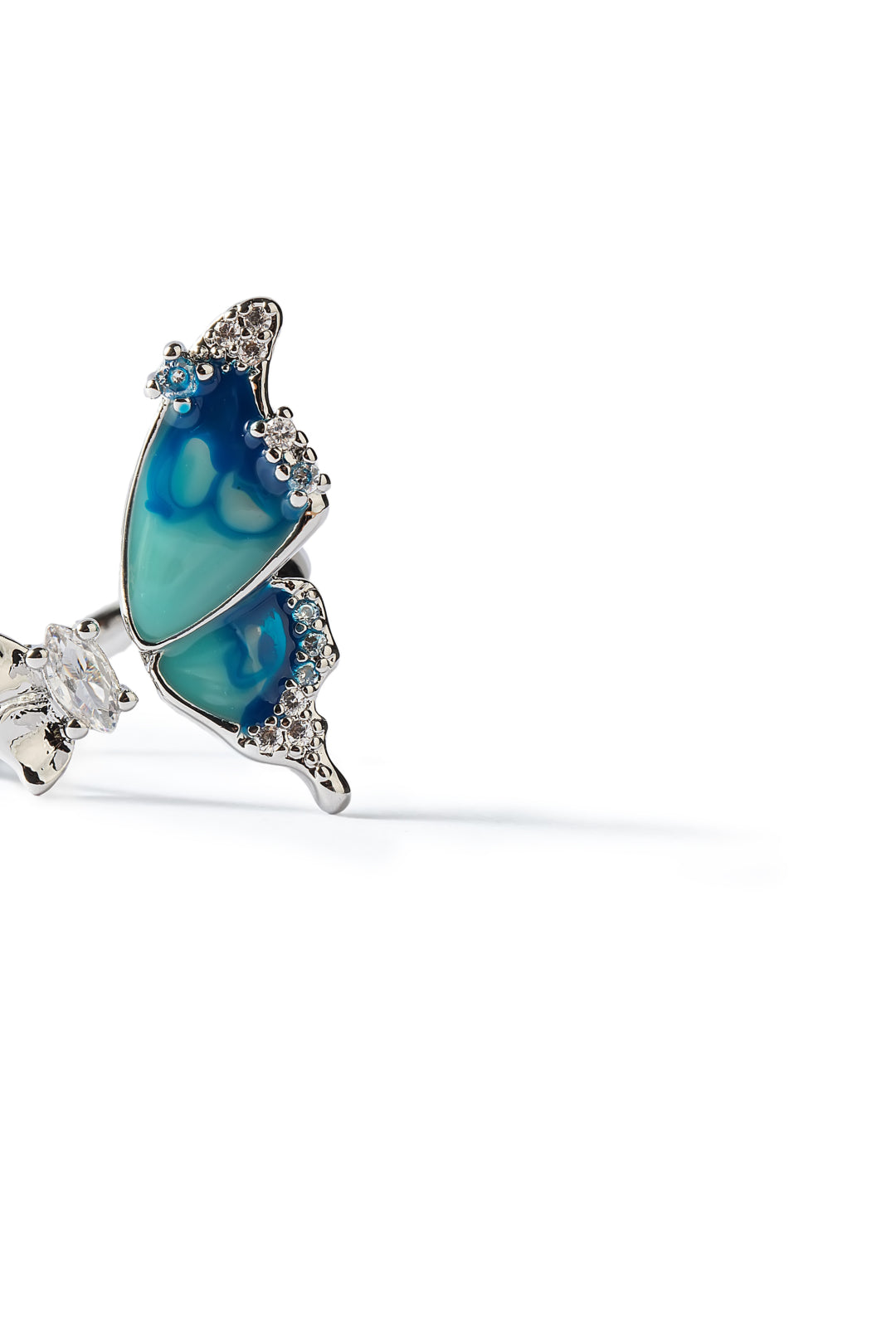 Side view of the Aiko Tanaka Ran no Cho butterfly ring showing teal enamel wings and a crystal-set silver band