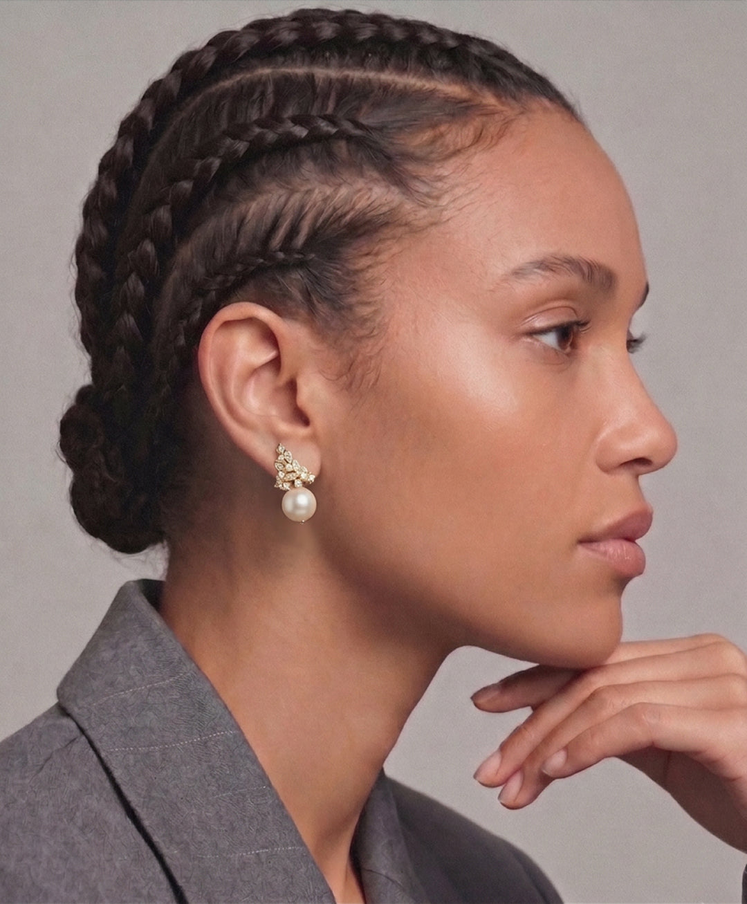Woman with braided hair in a grey blazer wearing the Aiko Tanaka Ritsu no Hikari gold crystal and pearl earring