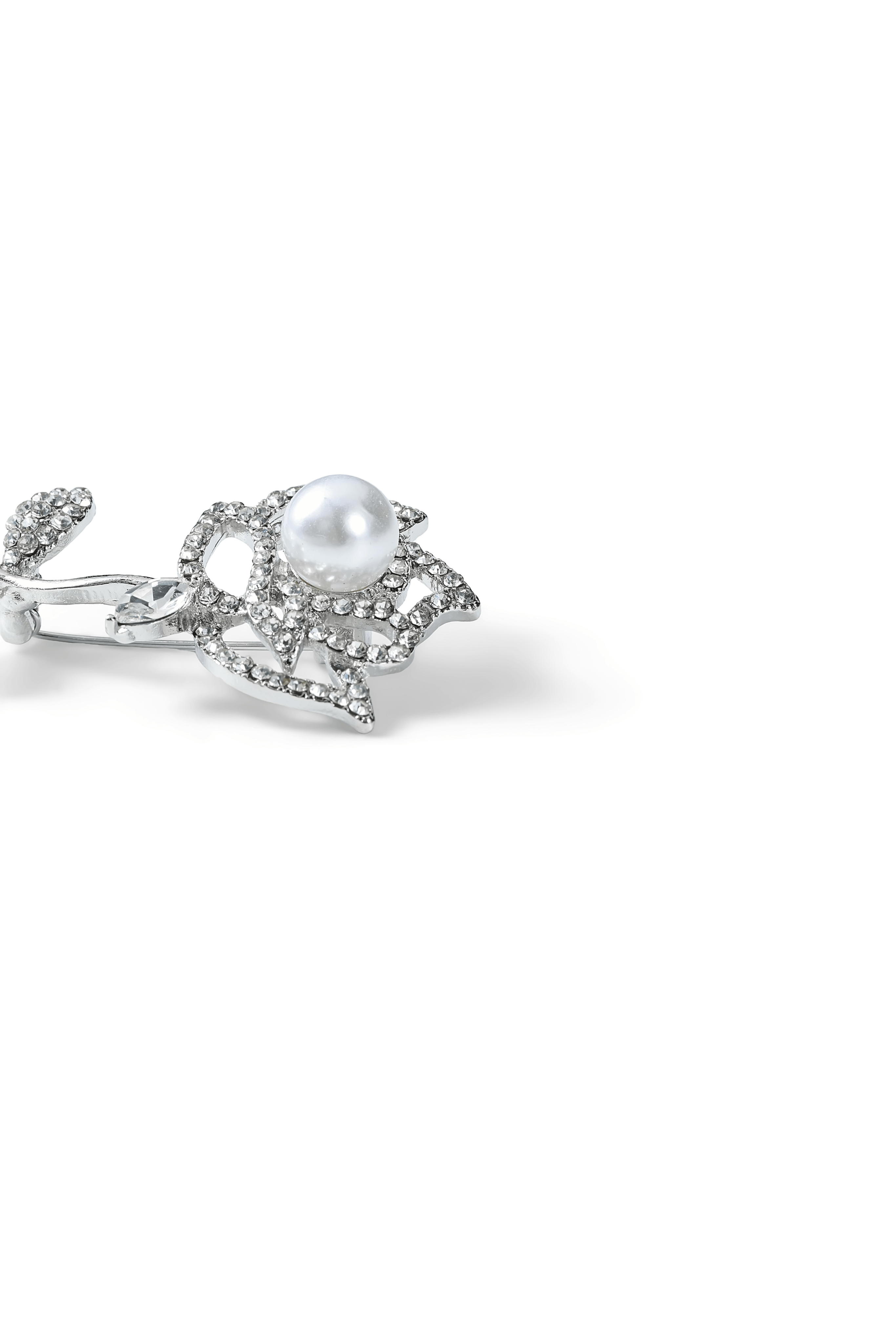Side view of the Aiko Tanaka Shiro Bara silver crystal rose brooch with its white pearl center, on a white background