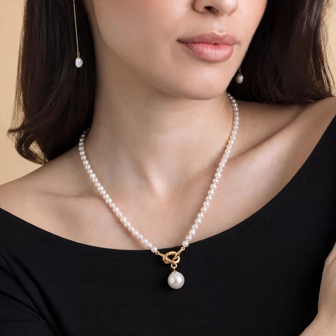 Woman in a black top wearing the Aiko Tanaka Shizuku no Chigiri pearl strand with a gold ring and pearl pendant