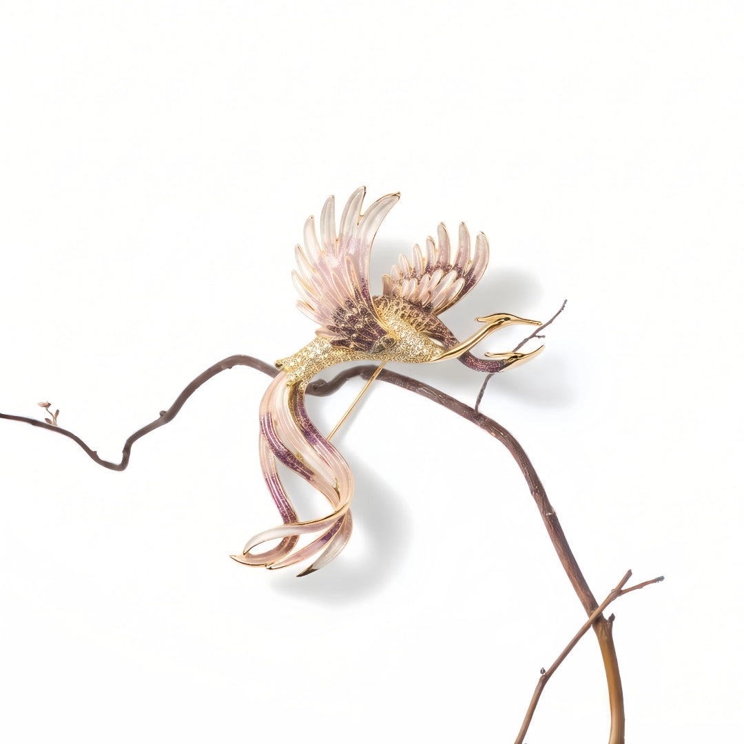 Aiko Tanaka Tsuru no Korin pink enamel crane brooch perched on a slender bare branch against a white background
