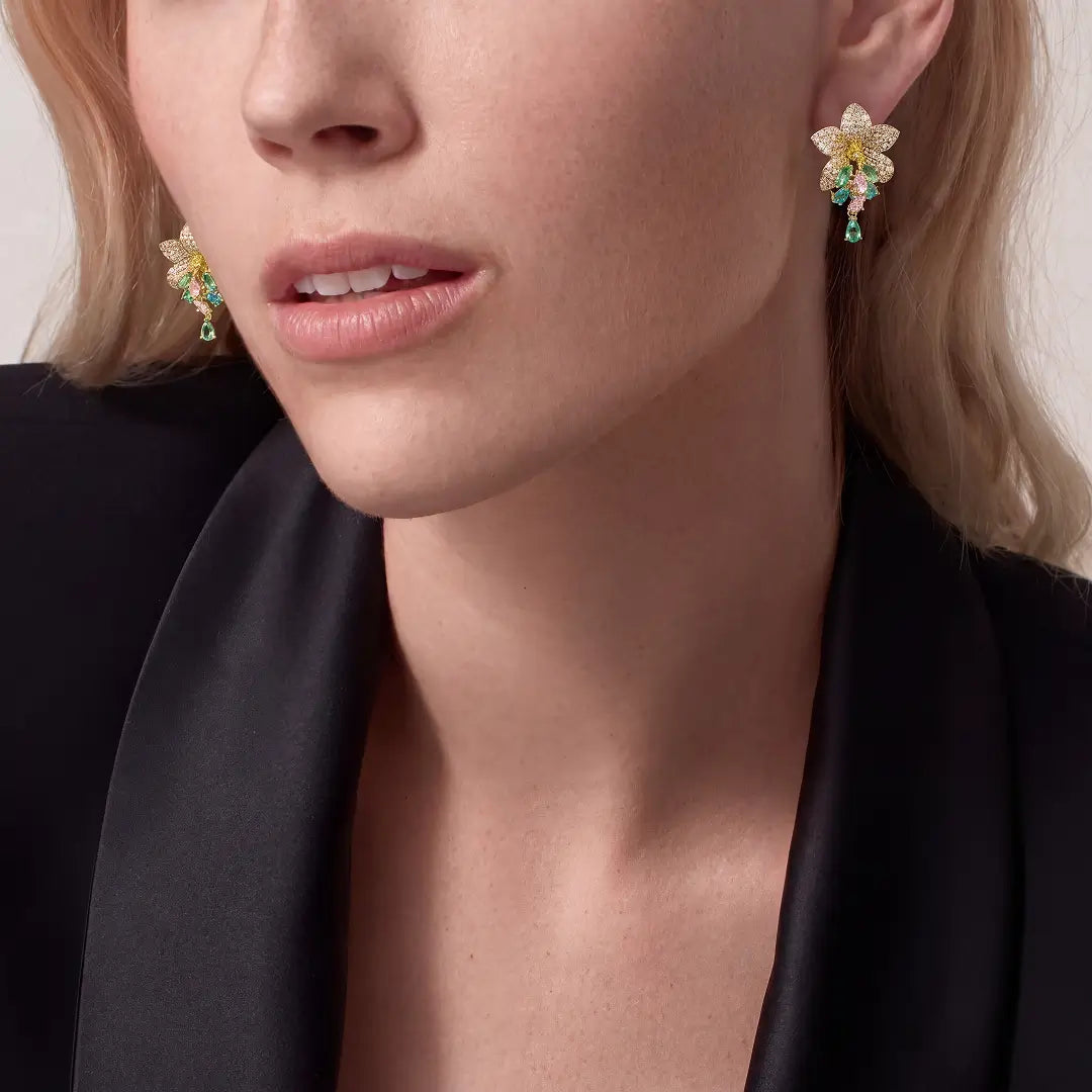 Woman in a black blazer wearing the Aiko Tanaka Wakana gold crystal flower earring with green accents